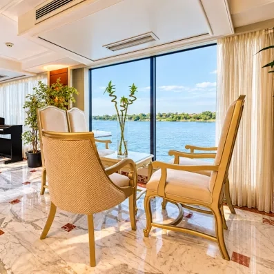 Salon panoramique élégant avec piano et vue sur le Nil, détente luxueuse au Caire, Égypte.