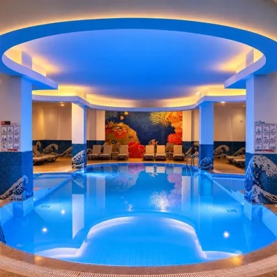 grande piscine intérieur avec des colonnes et illuminées