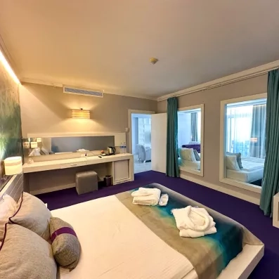 vue d'un lit double avec un balcon et un bureau