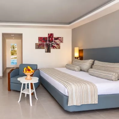 Suite élégante au César Thalasso Djerba avec coin salon, corbeille de fruits et décoration moderne épurée.