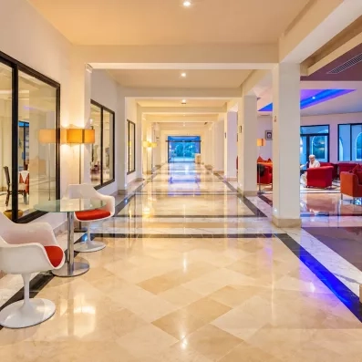 Couloir moderne et lumineux de l'hôtel César Thalasso Djerba menant aux espaces de vie et détente.