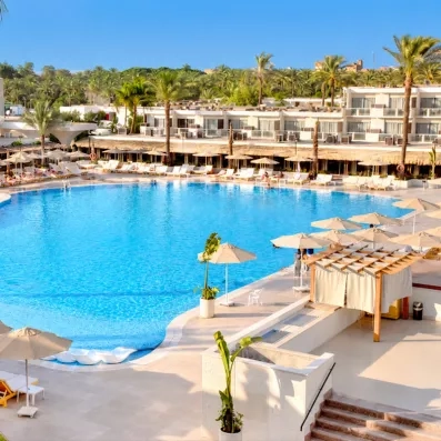Grande piscine avec transats de l'hôtel Pyramids Park au Caire pour un séjour détente tout compris.