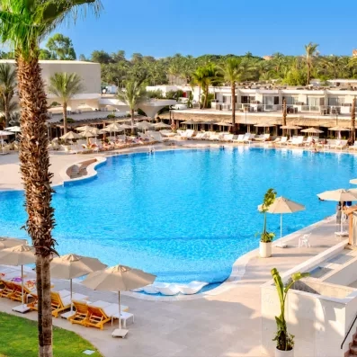 Grande piscine avec transats de l'hôtel Pyramids Park au Caire pour un séjour détente tout compris.