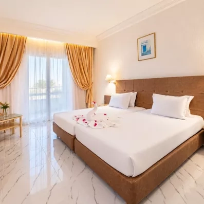 Chambre double élégante à l'hôtel Djerba Golf avec cygne en serviette et décoration romantique en Tunisie.