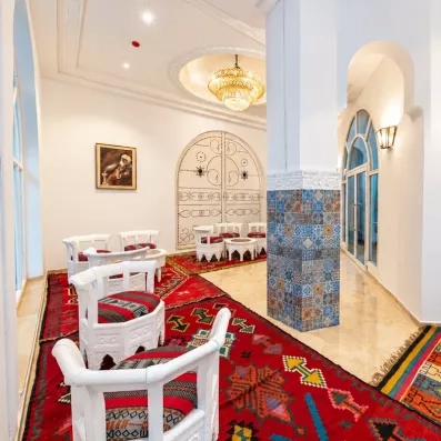 Salon traditionnel tunisien avec tapis colorés et architecture typique à l'hôtel Djerba Golf Resort & Spa.