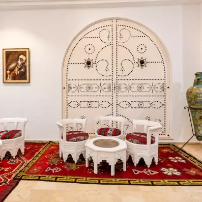 Salon traditionnel tunisien avec porte cloutée typique et jarre décorative à l'hôtel Djerba Golf.