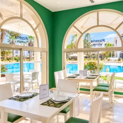 Pizzeria La Pergola lumineuse offrant une vue panoramique sur la piscine de l'hôtel à Djerba.