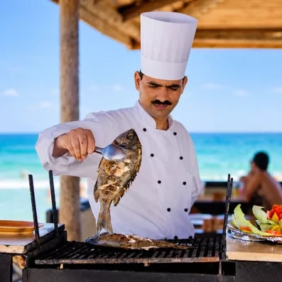 Chef préparant du poisson grillé en bord de mer au Djerba Aqua Resort Tunisie