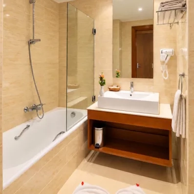 Salle de bain moderne de l'hôtel Djerba Resort équipée d'une baignoire et d'un plan vasque épuré.