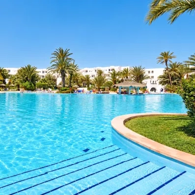 vue de la piscine  de jour avec les palmier de l'hotel Djerba Resort