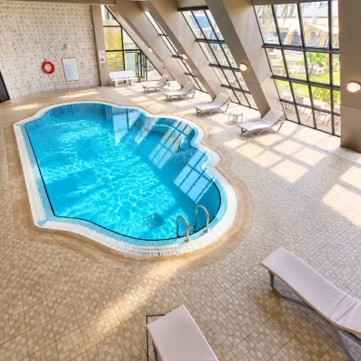 Piscine intérieur au centre de spa avec grande baie vitrée à l'hotel Helya Beach à Monastir en Tunisie