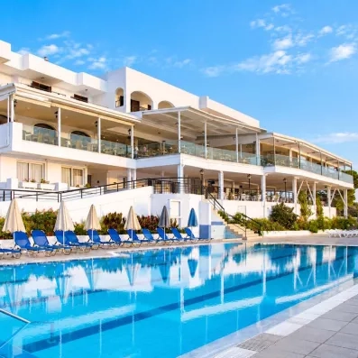 Vue générale de l'hôtel avec la piscine entourée des transats, le bâtiment et les terrasses