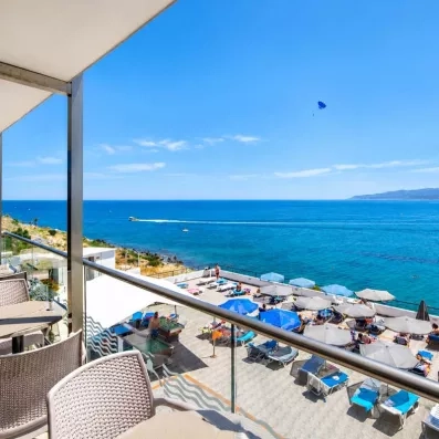 vue sur la mer depuis la terrasse du restaurant, un petit bateau et une parachute à la plage