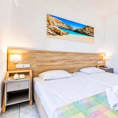 Chambre avec deux lits collés, une tête de lit en bois