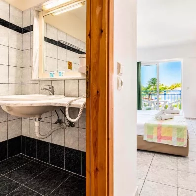 salle de bain avec une vasque avec un lavabo intégré et un grand miroir, juste à côté il y a la baignoire
