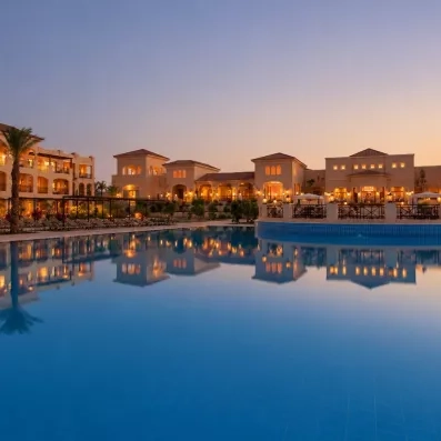 Vue de nuit du complexe au bord de la grande piscine extérieur