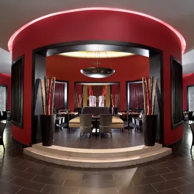 Design oriental moderne restaurant Jaz Aquamarine 5*, architecture circulaire rouge, ambiance tamisée Hurghada Égypte.
