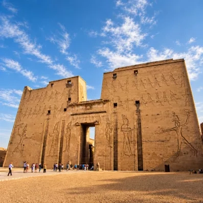 Grand pylône d'entrée gravé de dieux égyptiens au temple d'Edfou lors d'une escale de croisière sur le Nil.