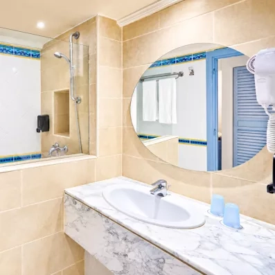 Salle de bain moderne avec vasque en marbre et douche à l'italienne à l'hôtel Les Quatre Saisons Djerba.