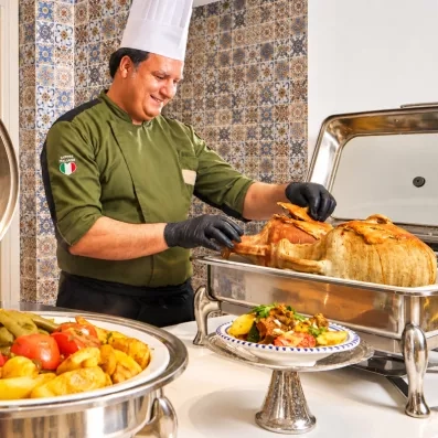Chef servant une spécialité culinaire traditionnelle tunisienne dans le restaurant de l'hôtel Les Quatre Saisons.