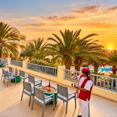 Service de thé à la menthe traditionnel sur une terrasse face aux palmiers à l'hôtel Les Quatre Saisons.
