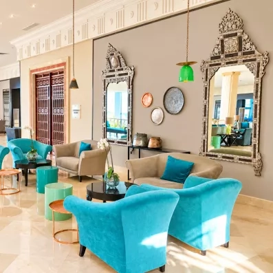 Salon de détente élégant avec fauteuils turquoise et décoration artisanale tunisienne au Royal Thalassa Monastir.