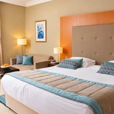 Décoration raffinée d'une chambre avec tête de lit capitonnée et coussins stylisés au Royal Thalassa Monastir.