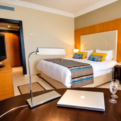 Chambre luxueuse avec bureau, ordinateur et vin rosé pour un séjour confort au Royal Thalassa Monastir.