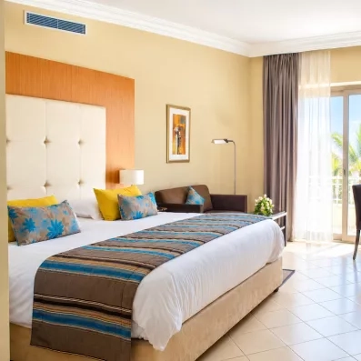 Suite lumineuse avec grand lit, coin bureau et vue dégagée sur l'extérieur au Royal Thalassa Monastir.
