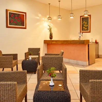 Bar intérieur convivial avec fauteuils en rotin et éclairage tamisé pour une soirée détente à Djerba.