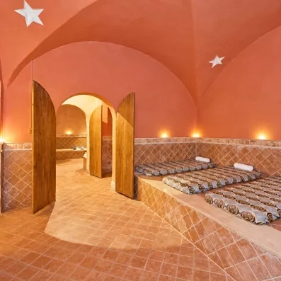 Salle de relaxation orientale du spa avec voûte rouge et matelas confortables au Safira Palms.