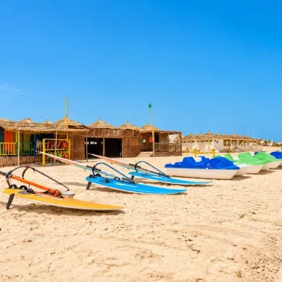 Activités nautiques et pédalos sur la plage de sable fin de l'hôtel Helios Beach à Djerba.