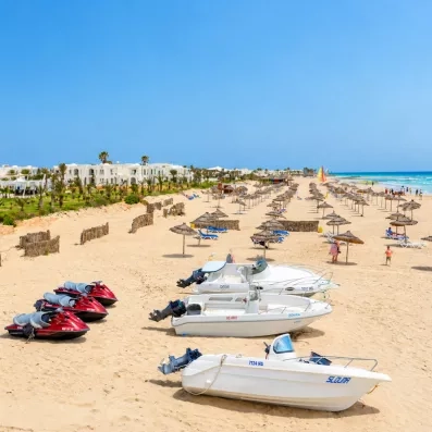 Activités nautiques et pédalos sur la plage de sable fin de l'hôtel Helios Beach à Djerba.