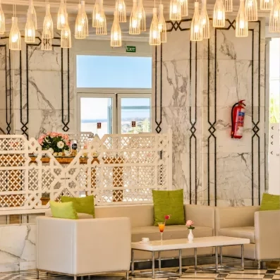 Salon de réception luxueux de l'hôtel Helios Beach à Djerba avec luminaires modernes et mobilier design.