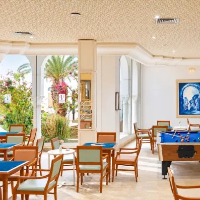 Salon de réception avec chaises tables et billard à l'hôtel Helios Beach à Djerba