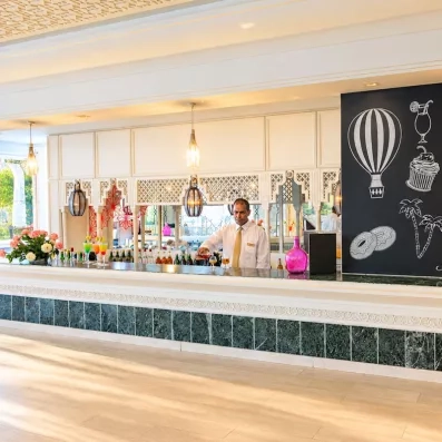 Bar moderne de l'hôtel Helios Beach à Djerba proposant des cocktails et rafraîchissements dans une ambiance décontractée.