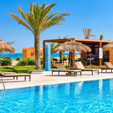piscine principale avec transats parasols et palmiers au Helios Beach en Tunisie à Djerba