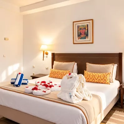 Une chambre préparée avec attention, ornée de pétales de roses et de serviettes pliées en forme de cœur, pour une escale toute en douceur.