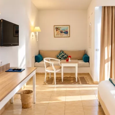 Un coin salon cosy avec banquette et petite table, idéal pour se détendre ou travailler tranquillement dans sa chambre.