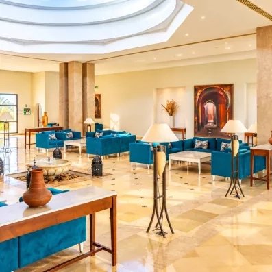 Un lobby spacieux et élégant, aux tons bleu paon et beige, alliant confort et raffinement méditerranéen.