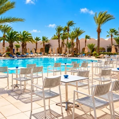 Un espace détente en bord de piscine, entouré de transats et de palmiers, parfait pour profiter du soleil.