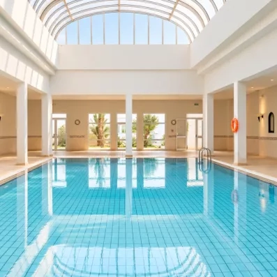 Une piscine couverte lumineuse, baignée de lumière naturelle grâce à sa verrière, idéale pour nager toute l'année.