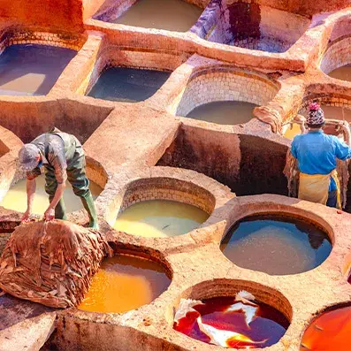 Tanneries de Fès avec cuves colorées et artisans au travail, scène emblématique de la médina marocaine