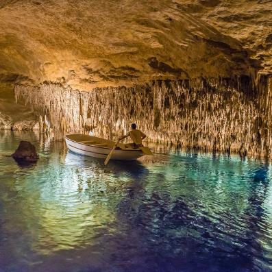 homme sur un bateau dans une grotte