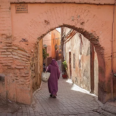 Ruelle de la médina de Marrakech, murs ocres, arcades traditionnelles et atmosphère authentique de la vieille ville marocaine.