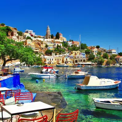 Île de Symi près de Rhodes avec port coloré et maisons pastel, quelques bateaux de pêcheurs