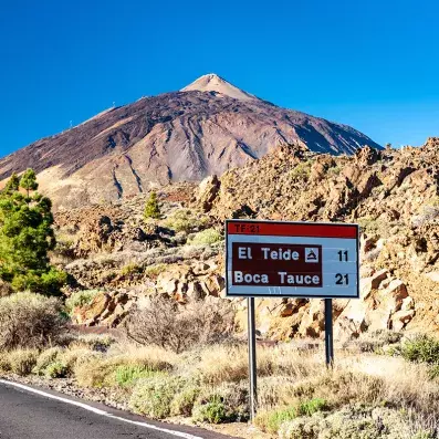 Volcan du Teide à Tenerife avec panneau routier, paysage aride et roches volcaniques dans le parc national du Teide.la distance pour y arriver