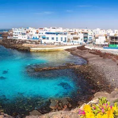 Maisons blanches d’El Cotillo à Fuerteventura, village de pêcheurs en bord de mer, eau turquoise et côte volcanique.