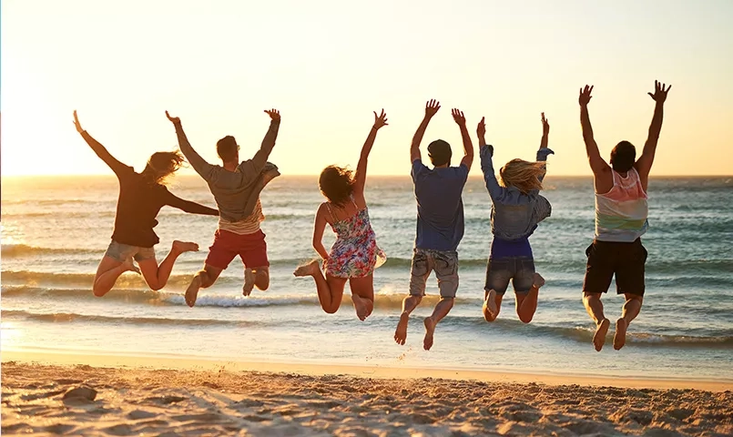Groupe d'amis sur la plage qui sautent