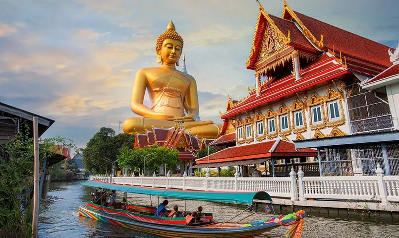 Bateau dans Bangkok avec un bouddha doré en arrière plan